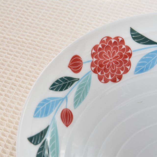 お皿の表面はまっすぐではなく波紋が広がったような形状になっています。縁の方に描かれた可愛らしいダリアのデザインはお料理やデザートを引き立ててくれます。